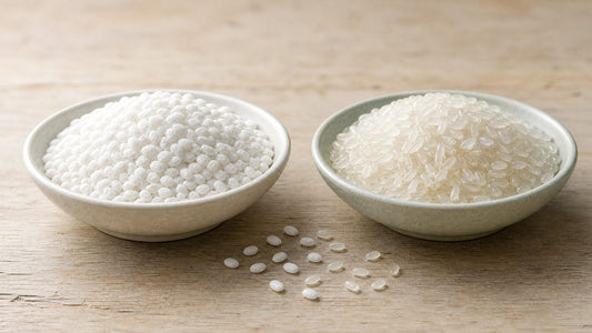 The mochi vs senbei split at the grain: a bowl of opaque chalk white mochigome rice beside a bowl of glassy translucent uruchi table rice, loose grains on pale wood.